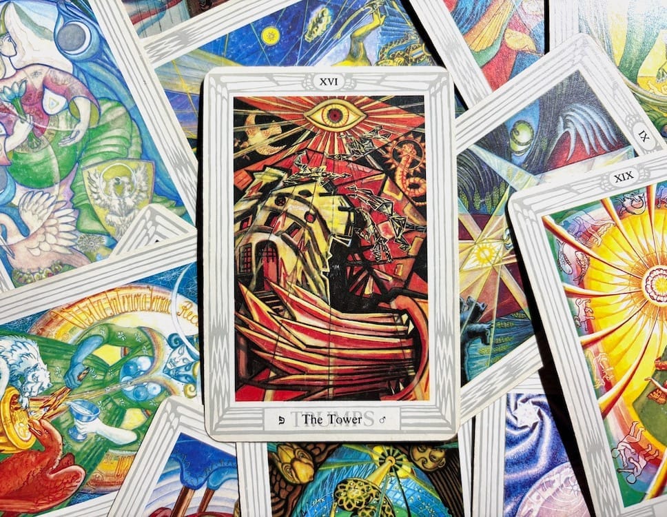 [The Tower card on top of other cards from the Major Arcana in the Thoth deck]